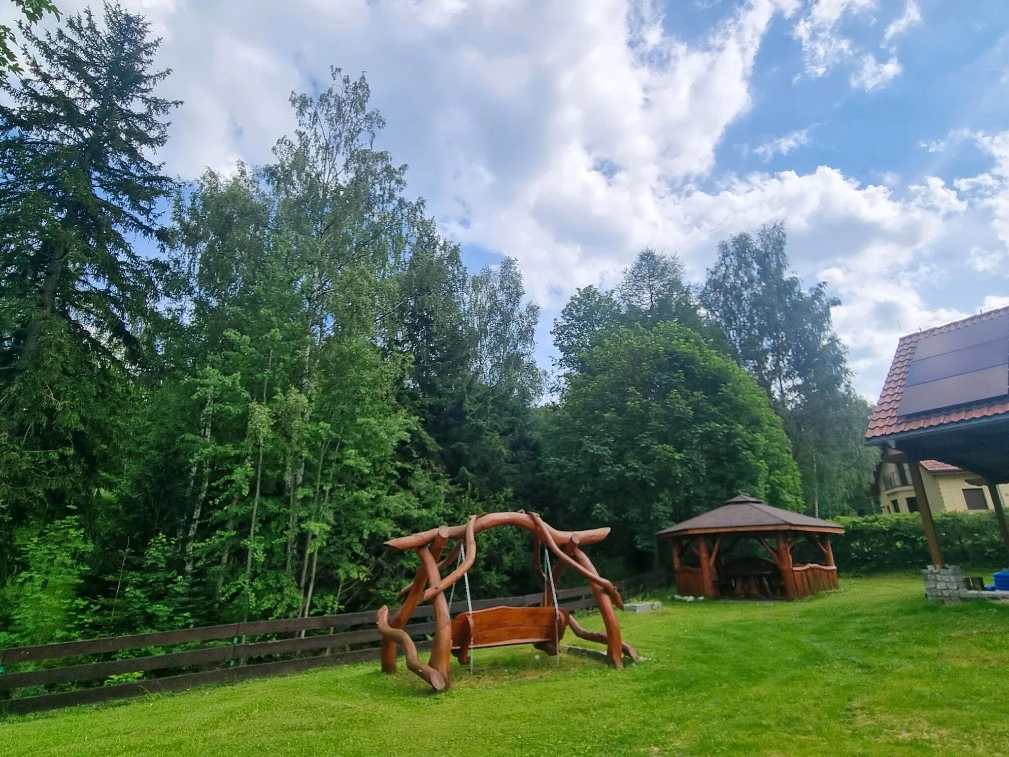 Ogród z altaną i drewnianą huśtawką